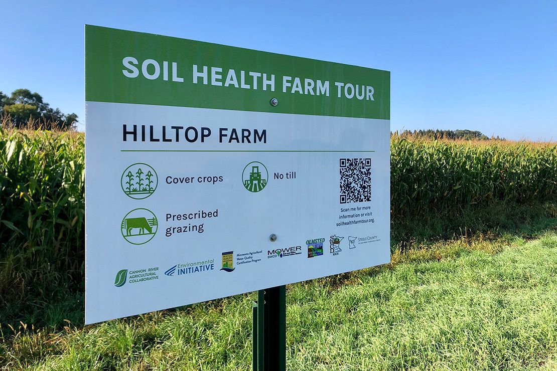 Soil health farm tour sign adjacent to corn field