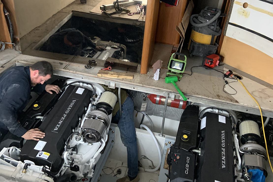 Man installing new engine on deep sea fishing boat.